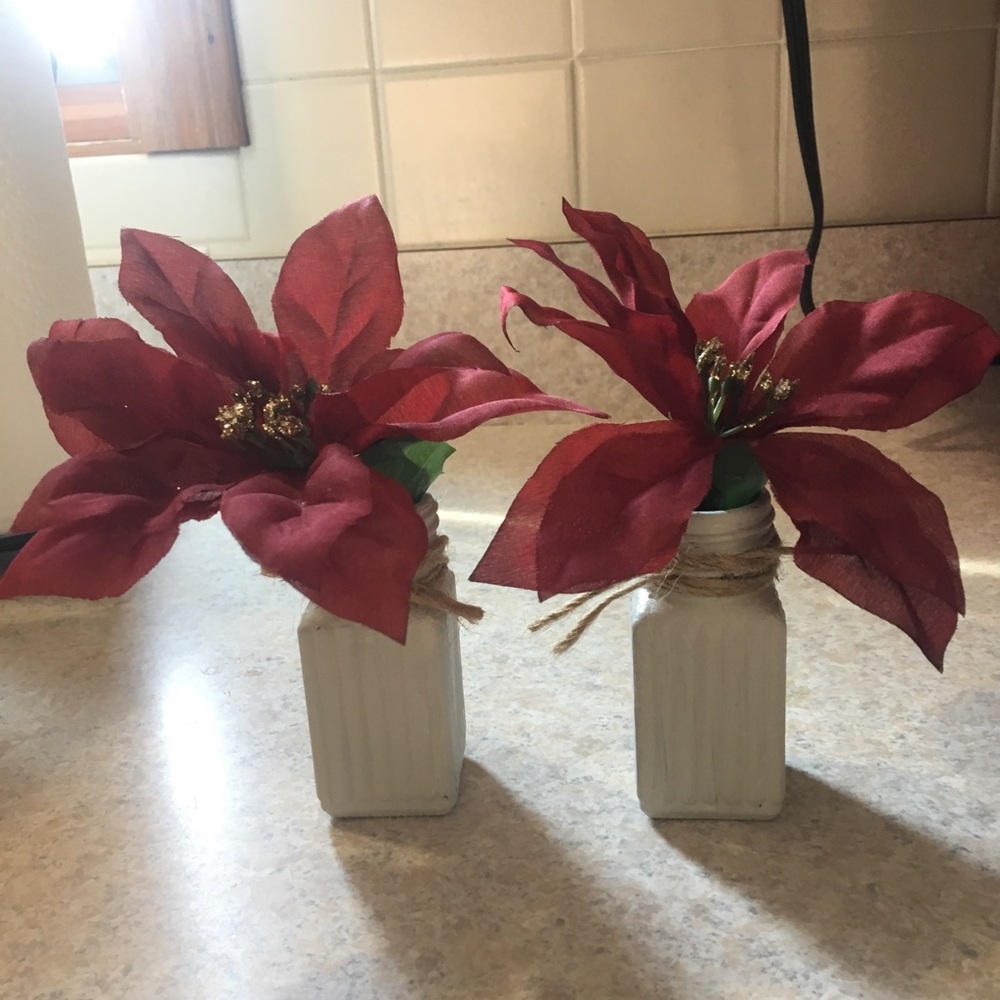 Set of glass jars with faux pointsetta plants.